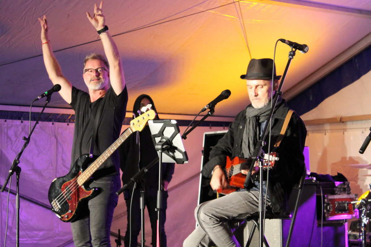 Ozvučenie kapely Hex na živej akcii pod stanom. Mikrofóny a hudobníci.